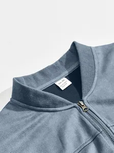 Close-up macro detail of men's suede zipper jacket with ribbed stand collar and tag
