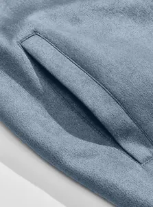 Macro detail of the high-quality blue suede fabric and pocket stitching on a men's jacket