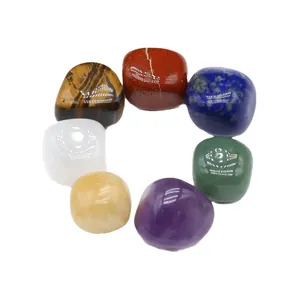 Set of seven natural colorful chakra healing tumbled stones in a circular arrangement