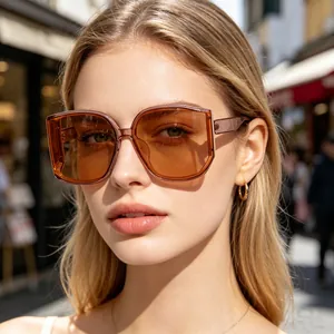 Close-up of stylish woman wearing oversized brown curved lens sunglasses outdoor