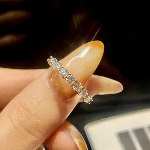 Close-up of sparkling S925 silver moissanite seven-stone row ring on finger.