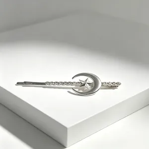 Close-up of silver-toned star and moon bobby pin with rhinestone details