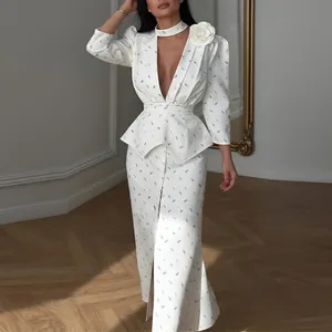 Elegante abito lungo bianco a fiori con scollo a V profondo, vita peplum e spilla floreale
