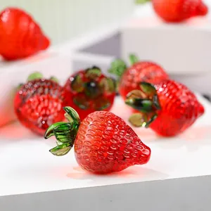 Close-up detail of handmade glass strawberry ornaments featuring realistic textures and shine