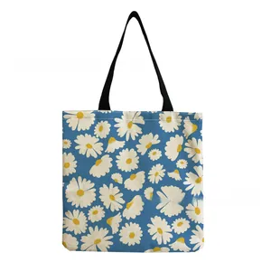 Close-up of blue tote bag with vibrant white and yellow daisy floral pattern