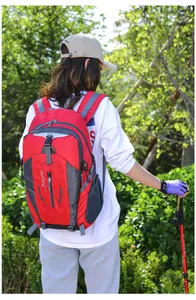 Large capacity red hiking backpack shown in use by a model in a natural outdoor setting
