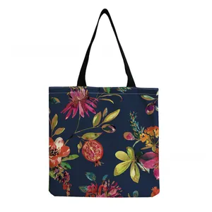 Close-up detail of a navy blue tote bag with vibrant floral and pomegranate patterns.