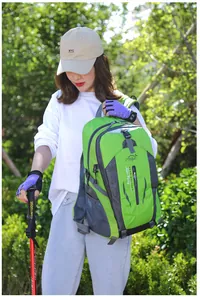Large capacity green hiking backpack worn by a model in a natural outdoor setting