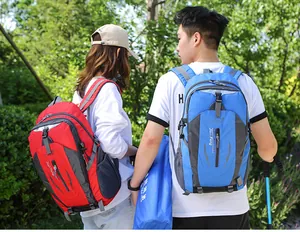 Couple carrying red and blue large capacity hiking backpacks in an outdoor setting