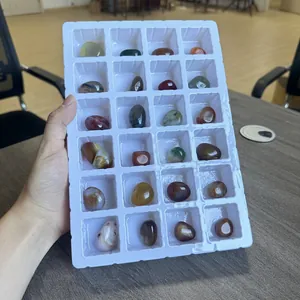 Detailed view of 24 polished natural stones in a white countdown calendar tray.