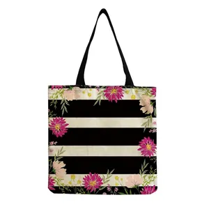 Close-up detail of pink floral pattern on a black and white striped canvas bag