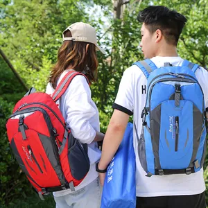 Male and female models wearing red and blue outdoor mountaineering backpacks in nature