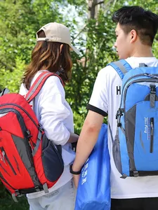 Couple wearing large capacity red and blue outdoor hiking backpacks during a forest trek