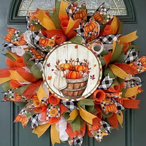 Autumn harvest wreath detail featuring Welcome Fall sign with maple leaf and pumpkin ribbons