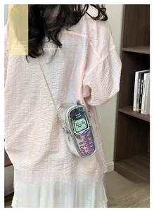 Primo piano di una mini borsa a tracolla argento trendy a forma di telefono retro