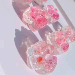 Close-up macro detail of transparent pink cat paw squishy toy with glitter resin finish
