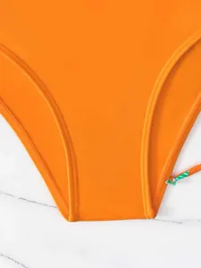 Dettaglio del fondo del bikini arancione brillante con cuciture di alta qualità