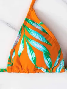 Dettaglio del top bikini a triangolo arancione con stampa di foglie tropicali mare