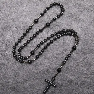 Long black bead necklace with hematite cross pendant in a religious rosary style