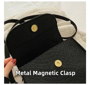 Detailed macro view showing the gold metal magnetic buckle of the snake pattern bag