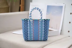 Detail view of colorful woven plastic tote bag with striped pattern on a sofa