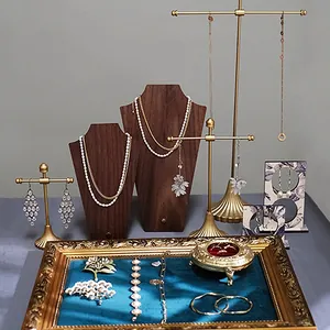 Vintage walnotenhouten sieradendisplay met gouden metalen rekken voor kettingen en oorbellen.