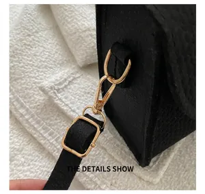 Close-up of premium golden metal hook and adjustable strap on a black felt shoulder bag
