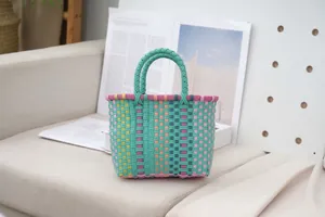 Detailed view of a multi-colored woven plastic tote bag in a cozy home setting