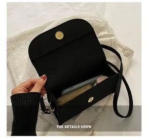 Detail view of the spacious interior capacity of the black felt small crossbody bag