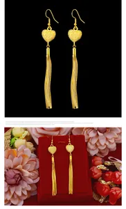 Golden heart-shaped tassel drop earrings displayed on black and floral backgrounds.