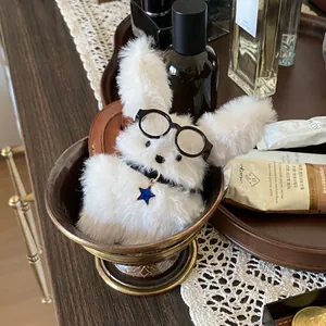 Close-up of cute white fluffy rabbit plush keychain with glasses and star charm