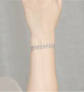 Close-up view of a 925 sterling silver moissanite paved Cuban link bracelet worn on a wrist