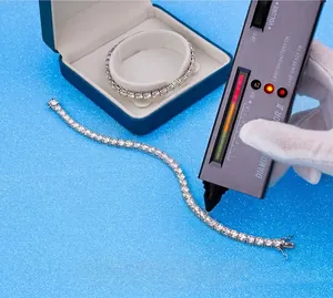 Close-up view of moissanite tennis bracelet passing a diamond tester on blue background