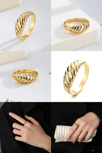 Close-up of a gold-tone croissant style ring with twisted design details.