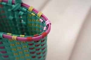 Detailed macro view of a colorful woven plastic tote bag rim showing craftsmanship