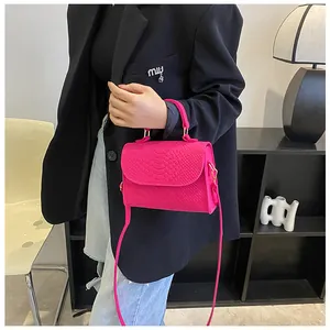 Close-up of hot pink snakeskin pattern felt small square handbag with crossbody strap