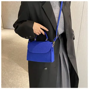 Stylish blue felt handbag featuring snakeskin texture and versatile crossbody strap