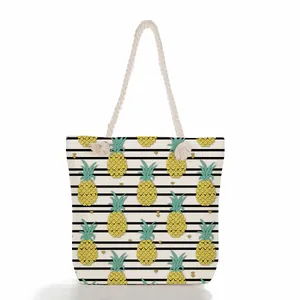 High-quality detail of a large beach tote bag with pineapple print and rope handles