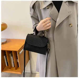 Chic black snake pattern mini square handbag styled perfectly with a grey trench coat