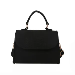 Elegant black felt handbag with snake pattern texture and polished gold hardware detail
