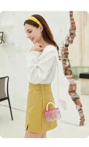 Model side view of a stylish mini gradient jelly bag with pearl handle and gold chain