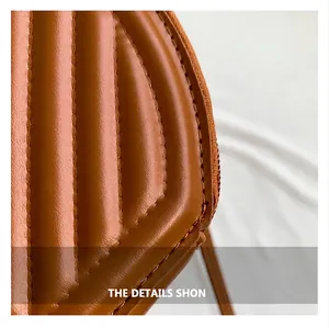 Close-up of brown quilted faux leather texture on fashionable round crossbody bag