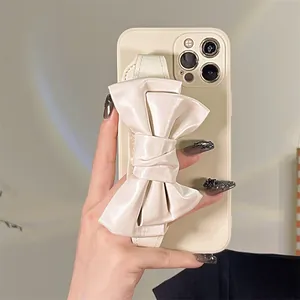 Elegant cream iPhone case featuring a large decorative bow wristband strap for girls