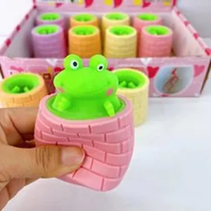 Close-up of a cute green frog popping out from a pink squeeze toy for stress relief
