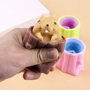 Detail view showing a hand squeezing a brown squirrel stump pop-up stress relief fidget toy