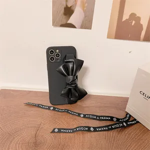 Detailed view of black leather bow wrist strap on iPhone case