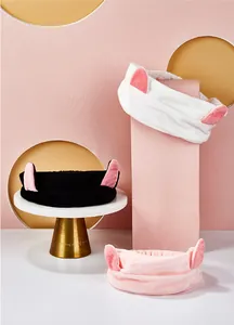 Détail rapproché des bandeaux avec oreilles de chat en peluche blanc, noir et rose.