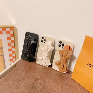 Detailed shot of stylish iPhone cases featuring large leather bow wristbands in three colors