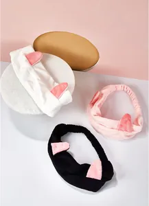 Vue détaillée des bandeaux en peluche oreilles de chat en blanc, rose et noir.