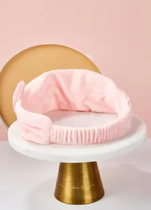 Vue détaillée d'un bandeau oreilles de chat rose sur support en marbre